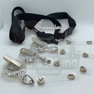 May include: A black breakaway lanyard with a retractable reel and a variety of clips, including a swivel clip, a belt slide clip, and a clip without a swivel. The lanyard is shown with clear plastic badge holders with metal eyelets.