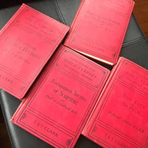 Puede incluir: Cuatro libros de tapa dura rojos con títulos de texto negro. Los títulos son "Scottish Church History", "Foundation Truths of Scripture", "Haggai, Zechariah, Malachi" y "The Life of St. Paul". Todos los libros son publicados por T&T Clark.