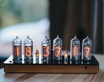 Reloj Nixie IN-14 en una delgada caja de madera con cubierta superior de plástico.