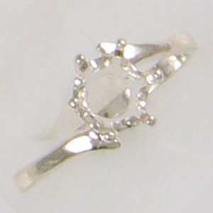May include: A silver ring with a round setting for a gemstone. The ring has a simple, elegant design.