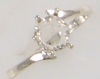May include: A silver ring with a round setting for a gemstone. The ring has a simple, elegant design.