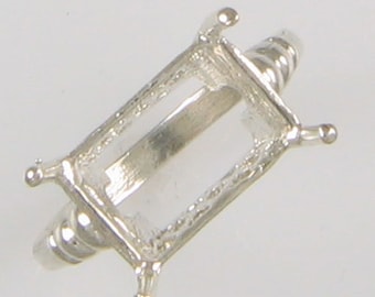 May include: Silver ring setting with an emerald-shaped bezel. The setting is designed to hold a gemstone.