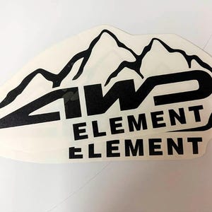 May include: Off-white sticker featuring the text "4WD ELEMENT" in bold black letters, with a mountain range graphic above. The sticker has a slightly irregular shape and is likely designed for vehicles or outdoor gear.