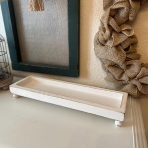 Rustic handcrafted wooden tray with smooth edges and a natural finish, available in customizable colors. The tray features a simple elegant design, perfect for serving as a decorative piece in any room.