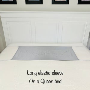 May include: A gray elastic bed sheet fitted over a queen-sized bed. The text "Long elastic sleeve On a Queen bed" is visible below the sheet.