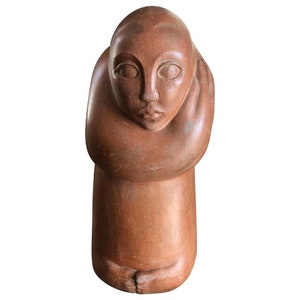 May include: A terracotta sculpture of a person with their arms crossed over their chest, looking down. The sculpture is a reddish-brown color and has a smooth, polished finish.
