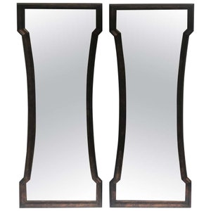 May include: A set of two arched mirrors with a dark brown wood frame. The mirrors have a simple, elegant design.
