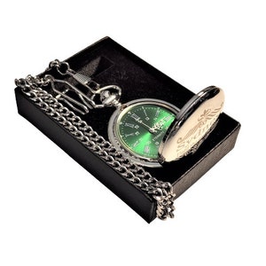 May include: A silver pocket watch with a green face and Roman numeral hour markers. The watch is in a black box with a silver chain.