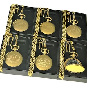 K&ouml;nnte beinhalten: Sechs goldene Taschenuhren mit Ketten in schwarzen Boxen. Jede Uhr hat einen anderen Namen und ein anderes Datum auf der Vorderseite eingraviert. Die Uhren sind alle im gleichen Stil gehalten und haben ein klassisches Aussehen.