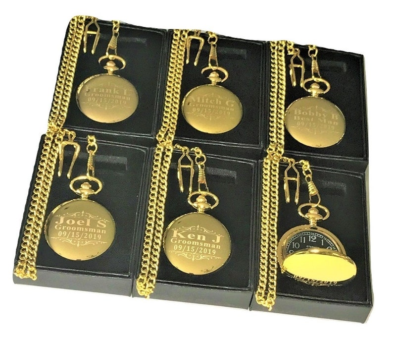 K&ouml;nnte beinhalten: Sechs goldene Taschenuhren mit Ketten in schwarzen Boxen. Jede Uhr hat einen anderen Namen und ein anderes Datum auf der Vorderseite eingraviert. Die Uhren sind alle im gleichen Stil gehalten und haben ein klassisches Aussehen.