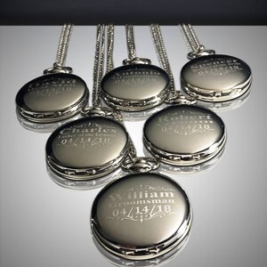 May include: Six silver pocket watches with engraved names and dates. The watches are on chains and arranged in a fan shape.