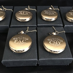K&ouml;nnte beinhalten: Sechs goldene Taschenuhren mit Ketten in schwarzen Boxen. Jede Uhr hat eine andere Inschrift: "Til the End of Time JMW", "Til the End of Time ALS", "Til the End of Time DSS", "Til the End of Time MSM", "Til the End of Time PAC" und "Til the End of Time CMY".