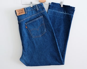 1970s Levi's orange tab 44" waist, blue medium wash denim jeans with cropped raw hem