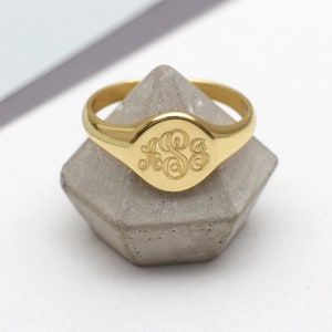 Op de afbeelding: Een gouden zegelring met een gegraveerde ovale bovenkant. Het monogram is de letters "F.S.S." in een schrijfletter.