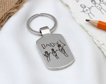 May include: Silver keychain with a rectangular tag engraved with a child's drawing of a family and the word "DADDY!"