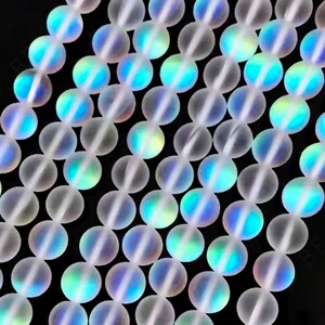 May include: A strand of iridescent white glass beads. The beads are round and have a frosted finish. They are strung on a clear thread.