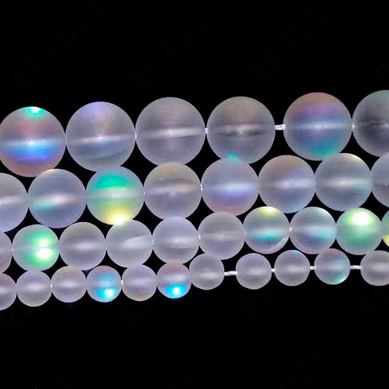 May include: A strand of iridescent white glass beads. The beads are round and have a smooth, frosted finish. The beads are strung on a clear elastic cord.
