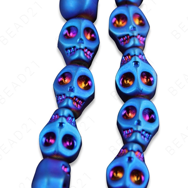 May include: A strand of blue and purple skull beads. The beads are made of hematite and have a shiny, metallic finish.