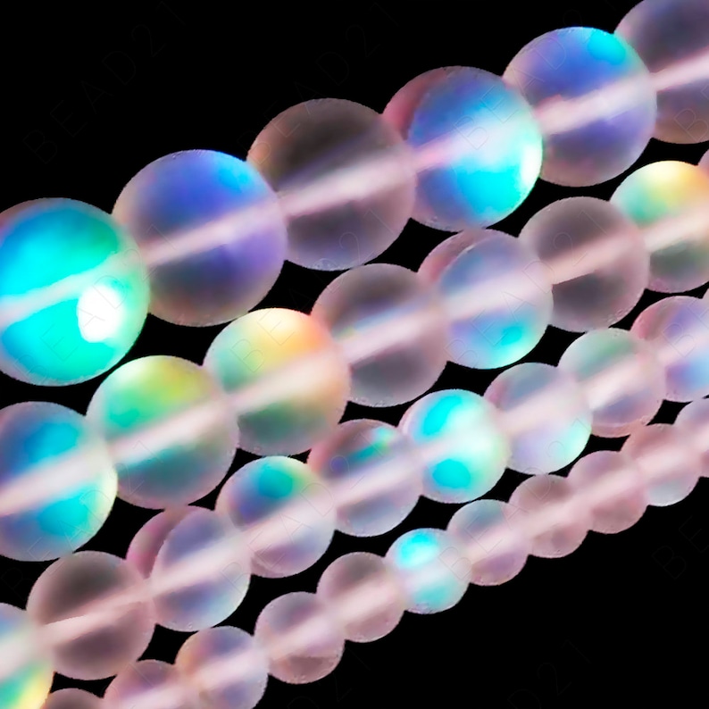 May include: A strand of iridescent, translucent pink beads. The beads are round and have a smooth, polished finish. The beads are strung together on a clear thread.