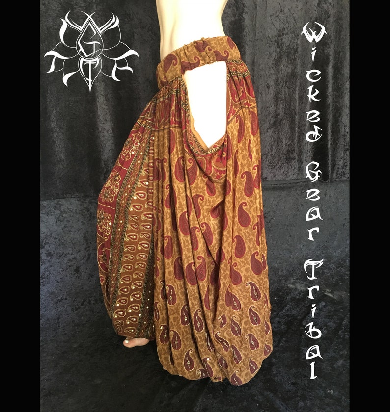 May include: Brown and maroon paisley print harem pants. The pants have an elastic waistband and a loose, flowing design. The words "Wicked Gear Tribal" are written vertically on the right side of the image.