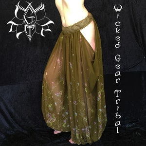 May include: Olive green tribal dance pants with a floral pattern. The pants have a wide waistband and a split design on the sides. The text "Wicked Gear Tribal" is visible on the right side of the image.