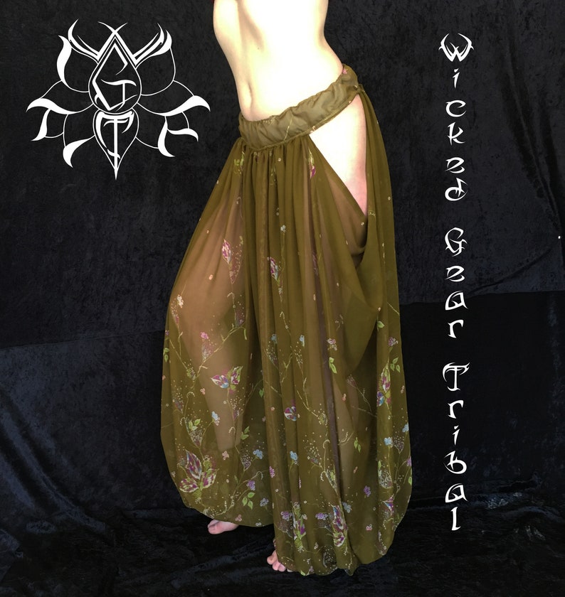 May include: Olive green tribal dance pants with a floral pattern. The pants have a wide waistband and a split design on the sides. The text "Wicked Gear Tribal" is visible on the right side of the image.
