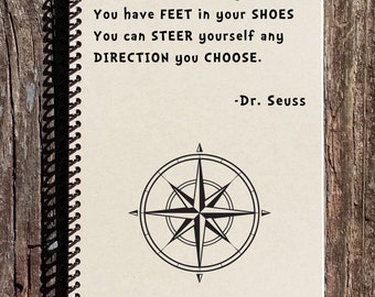 May include: A spiral bound notebook with a beige cover featuring a quote by Dr. Seuss: "You have BRAINS in your HEAD You have FEET in your SHOES You can STEER yourself any DIRECTION you CHOOSE."  The quote is printed in black text and is accompanied by a black and white compass illustration.