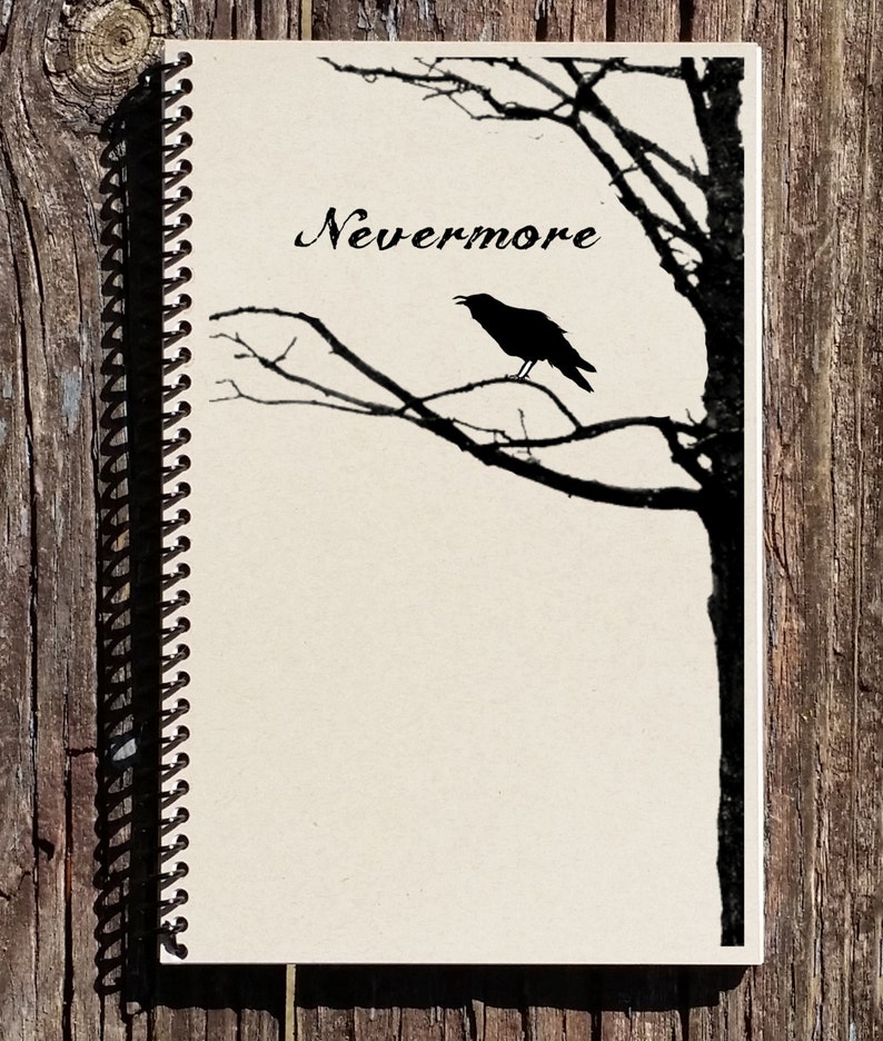 May include: A black and white spiral bound notebook with the word "Nevermore" written in cursive on the front cover. A silhouette of a raven perched on a bare tree branch is also on the cover.