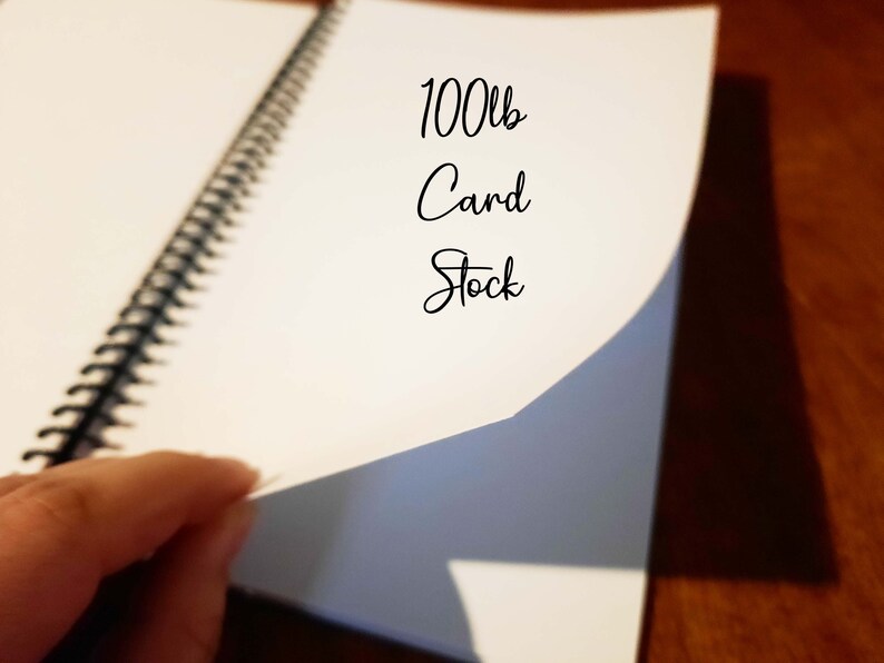 May include: A close-up of a white spiral bound notebook with the text "100lb Card Stock" written on the cover.