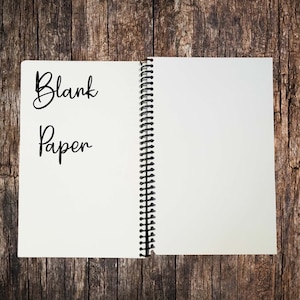 May include: An open spiral bound notebook with blank white paper. The words "Blank Paper" are written on the left page.