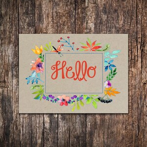May include: A brown card with a watercolor floral wreath surrounding a white rectangle with the word "Hello" in red lettering.