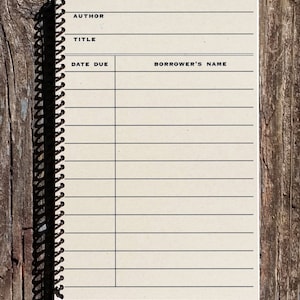 May include: A blank book with a spiral binding. The cover is beige and has black lines for writing. The words "AUTHOR", "TITLE", "DATE DUE", and "BORROWER'S NAME" are printed on the cover.