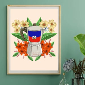 May include: A framed art print featuring a silver coffee maker with the Haitian flag on it, surrounded by orange and yellow flowers and green leaves. The background is a light beige color.