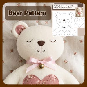 May include: A cream-colored plush bear with embroidered closed eyes and a brown nose. It features a pink satin ribbon bow with a small brass bell at the neck and a floral heart patch on the chest. An inset graphic shows a Teddy Bear Sewing Pattern.