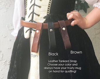 May include: Leather tankard straps in tan, black, and brown, with silver rivets and Celtic knot details. The image includes the text "Leather Tankard Strap. Choose your color and always have your trusty mug on hand for quaffing!"