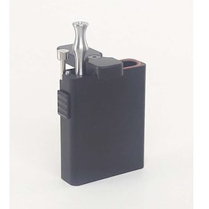 May include: A black metal case with a silver metal tool inside. The case has a hinged lid and a small compartment on the side.