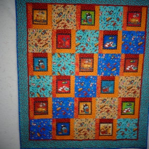 May include: A colorful quilt with a patchwork design featuring various patterns and colors, including blue, red, orange, and yellow. The quilt is made up of squares with different designs, including animals, geometric shapes, and floral patterns.