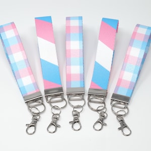 May include: Six keychains with a blue and pink plaid pattern and silver key rings.