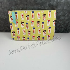 May include: A yellow cosmetic bag with a repeating pattern of women in swimsuits sunbathing on beach towels. The bag has a teal zipper pull and the text "Jenns Perfect Accessories".