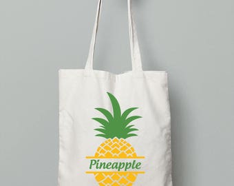 May include: A white canvas tote bag featuring a yellow pineapple graphic with the word "Pineapple" written in a green banner across the middle of the pineapple.