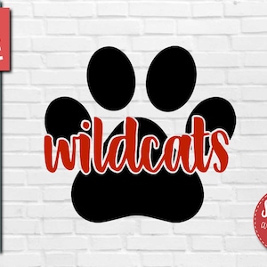 Op de afbeelding: Een zwarte pootafdruk met het woord "wildcats" in rode tekst in de afdruk.