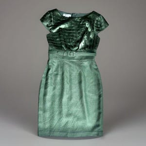 May include: A knee-length emerald green dress featuring a structured bodice with horizontal satin ribbon detailing, short cap sleeves, and a matching fabric belt with a rectangular buckle at the waist. The skirt has a textured, woven appearance.