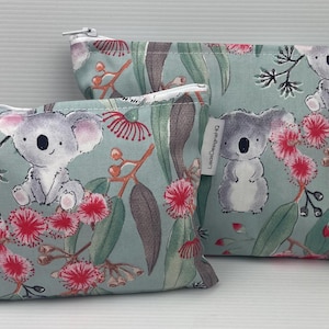 Estuche organizador de maquillaje con diseño de koala australiano y eucalipto en flor, con cremallera blanca y monedero de algodón australiano.