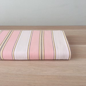 May include: Pink and white striped fabric with thin yellow and brown stripes.