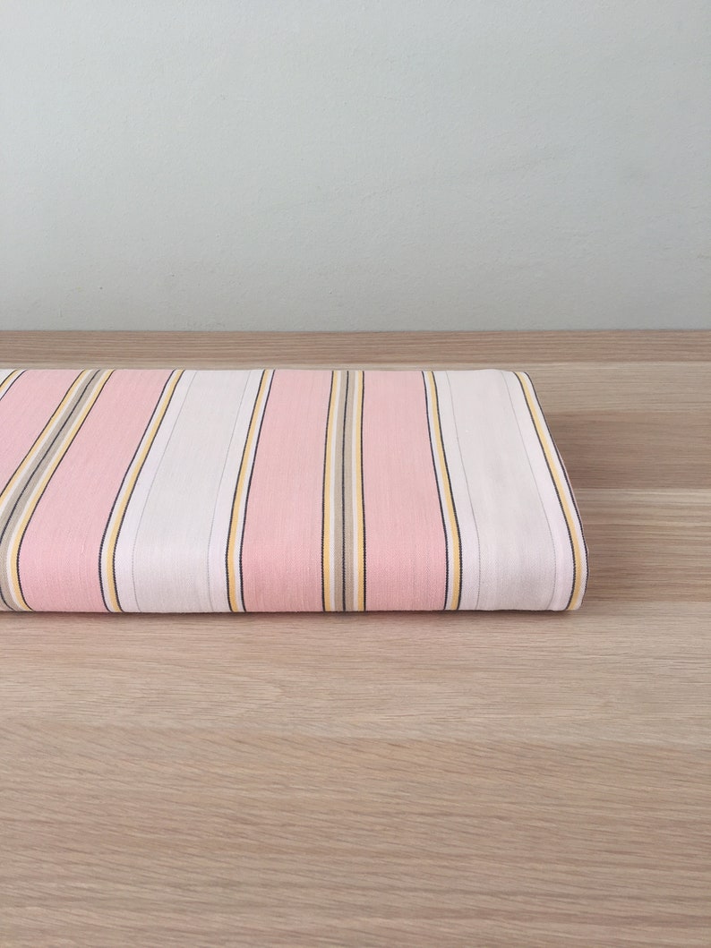 May include: Pink and white striped fabric with thin yellow and brown stripes.