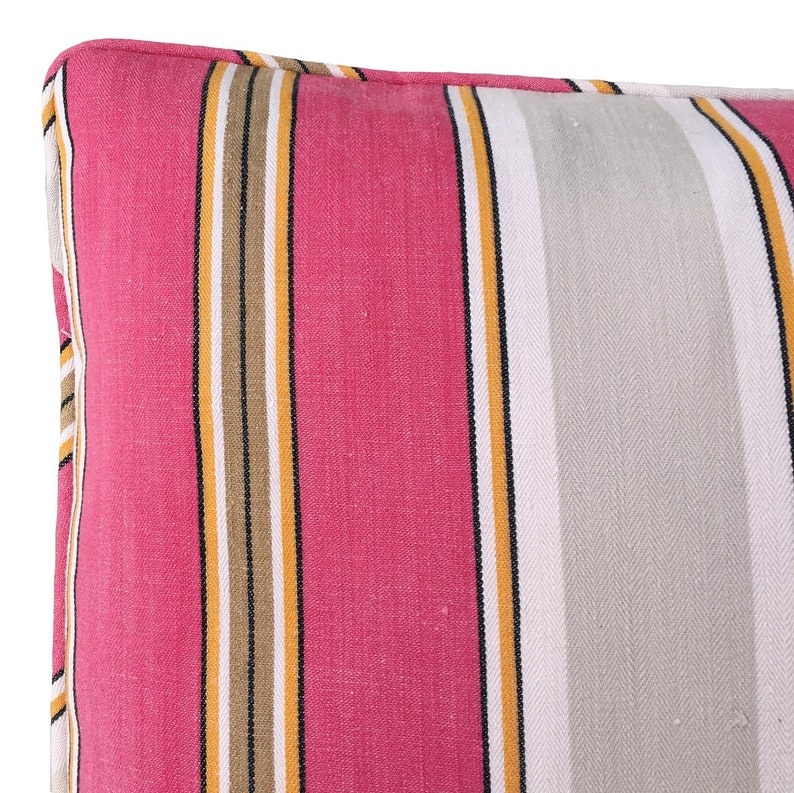 May include: A pink, gray, black, and yellow striped pillow cover. The fabric has a subtle herringbone pattern.