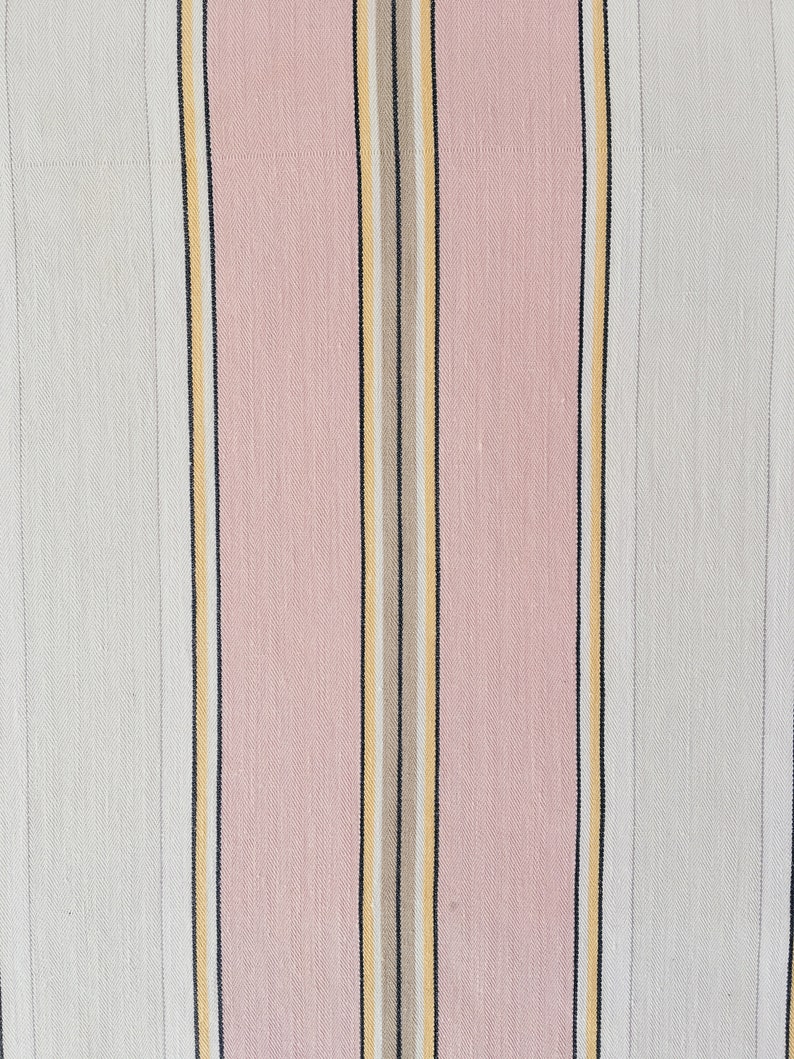 May include: A close-up of a fabric with vertical stripes in pink, white, black, and yellow.