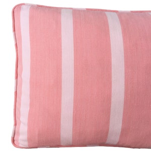 May include: A pink and white striped lumbar cushion with a soft, textured fabric.
