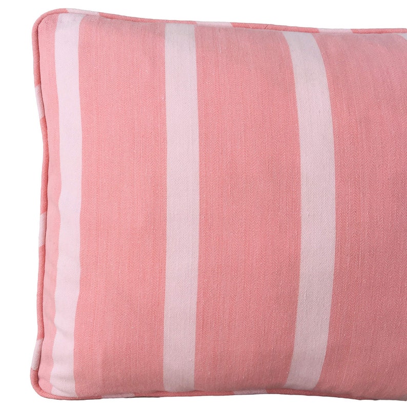 May include: A pink and white striped lumbar cushion with a soft, textured fabric.
