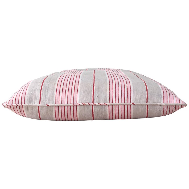 May include: A rectangular gray and pink striped cushion with red stripes. The cushion is made of a soft, woven fabric and has a simple, classic design.